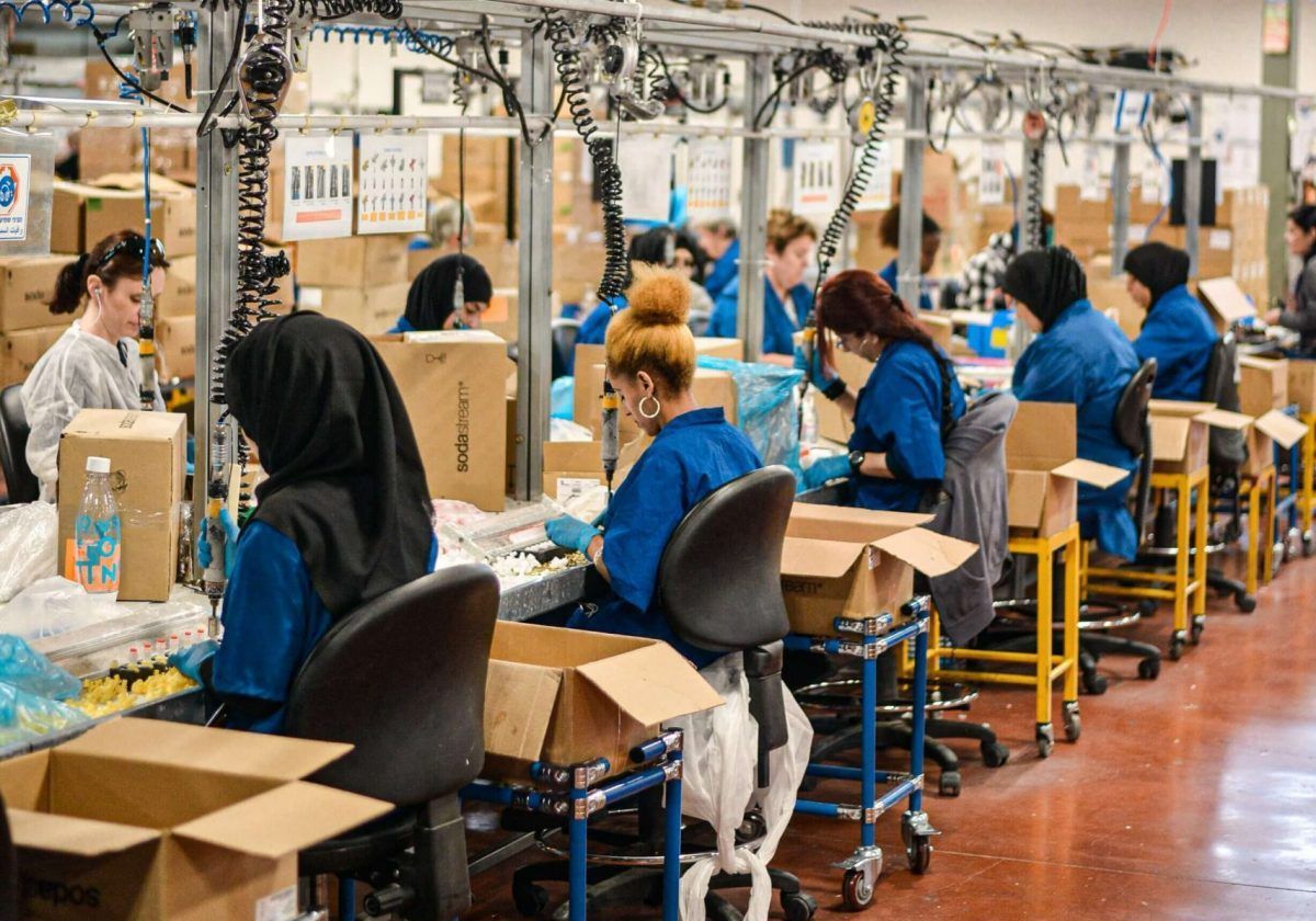 Lavoratrici alla loro postazione in una fabbrica tessile