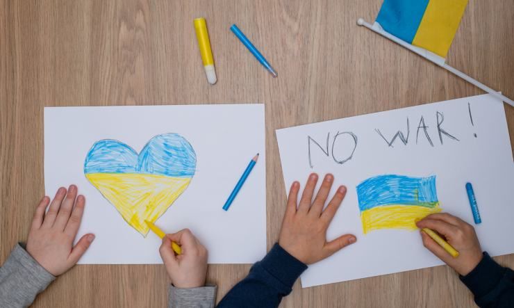 Bambini disegnano un cuore e una scritta con i colori dell'Ucraina