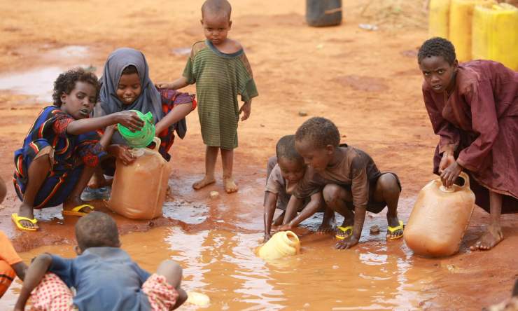 Bambini prendono acqua da una pozza