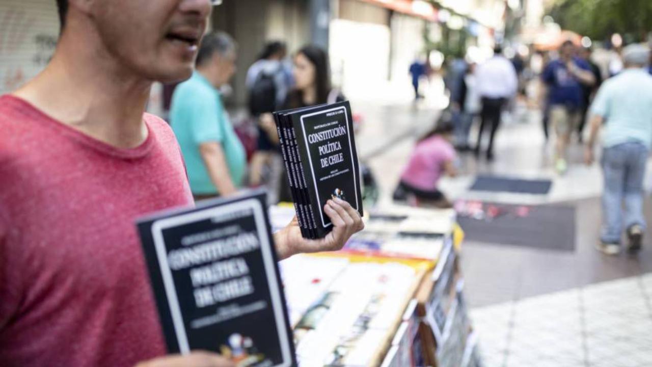 In Cile un ragazzo distribuisce copie della Costituzione