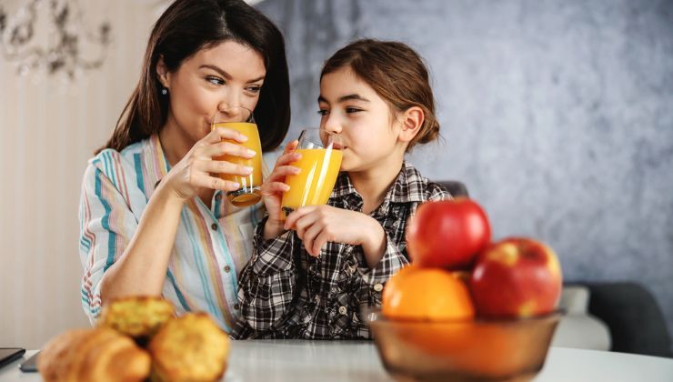 Mamma e figlia bevono un succo di frutta