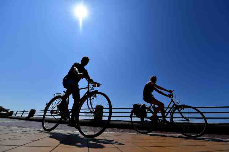 Persone in bici sotto il sole