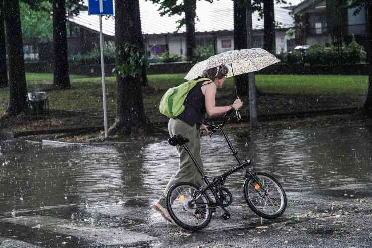 Persona in bici sotto la pioggia