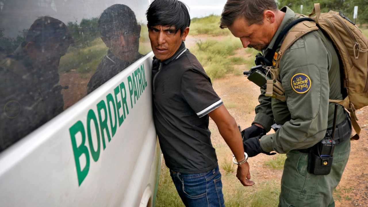 Un agente della polizia USA arresta un migrante irregolare che ha superato la frontiera