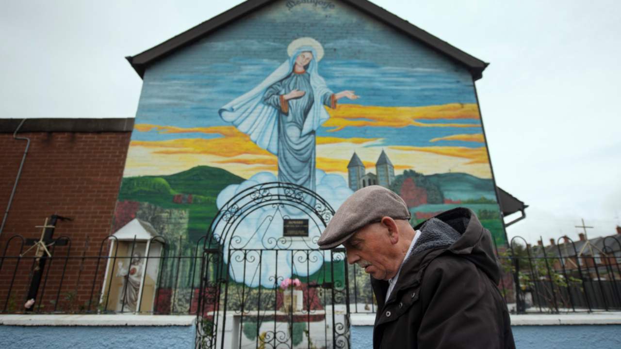 Un signore passa davanti ad una chiesa cattolica a Belfast