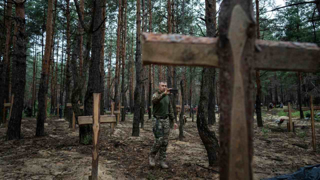 Un soldado fotografa le immagini delle tombe ritrovate