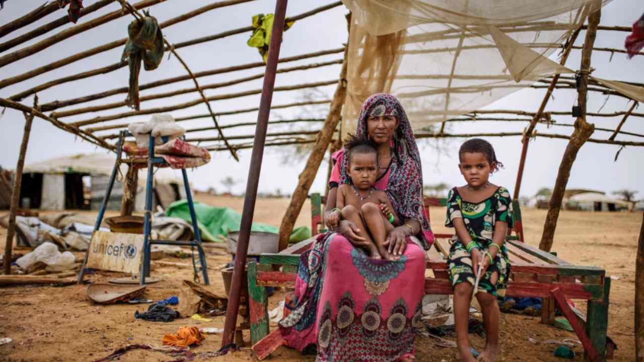 Una donna del Burkina Faso ed i suoi bambini in un campo profughi