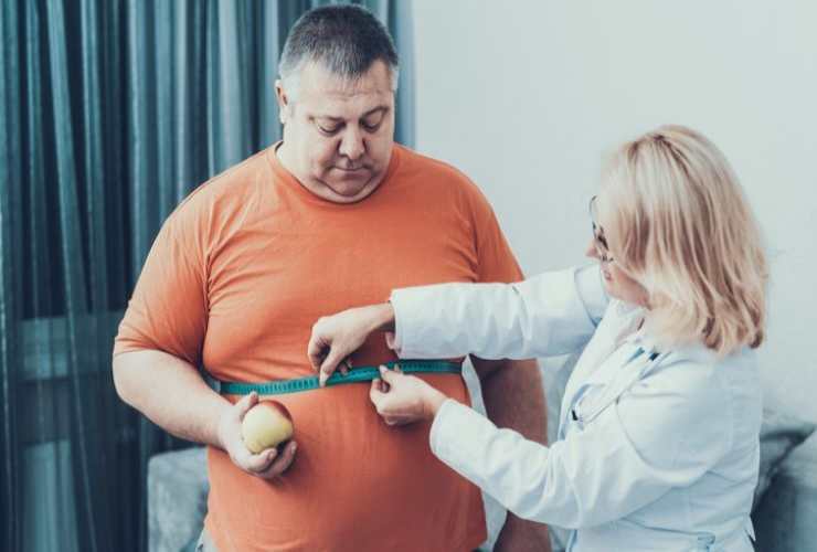 Dottoressa che visita una persona obesa