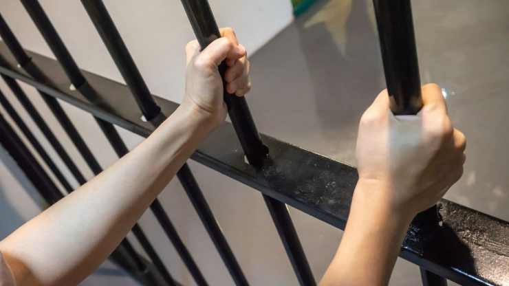 Braccia di un detenuto alla sbarra