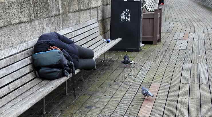 Persona che dorme su una panchina