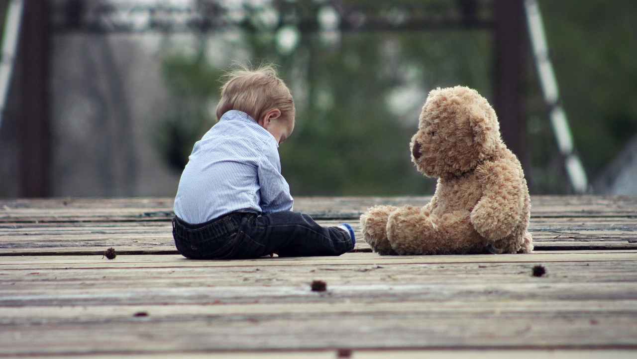 Bambino con orso di peluche