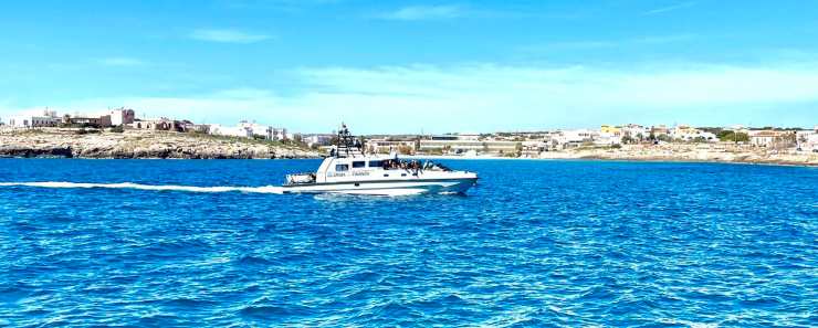 Guardia di finanza con a bordo migranti