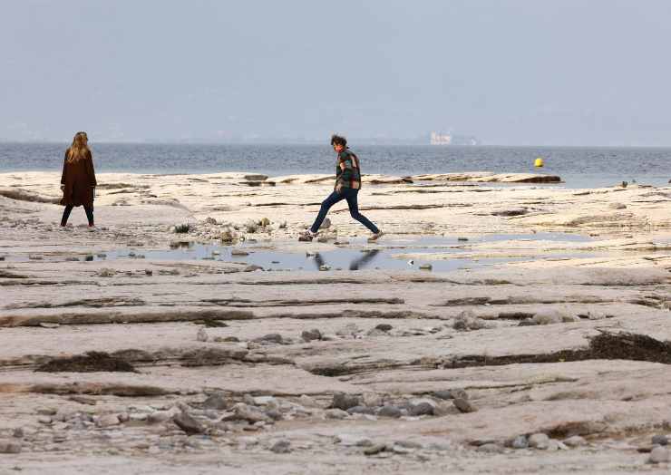 Persone che camminano sulla secca di un fiume