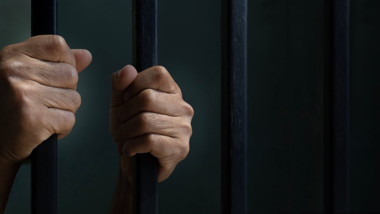 Mani su sbarre di una cella