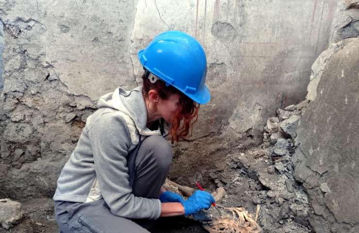 Una archeologa durante la scoperta degli scheletri di due nuove vittime di un terremoto