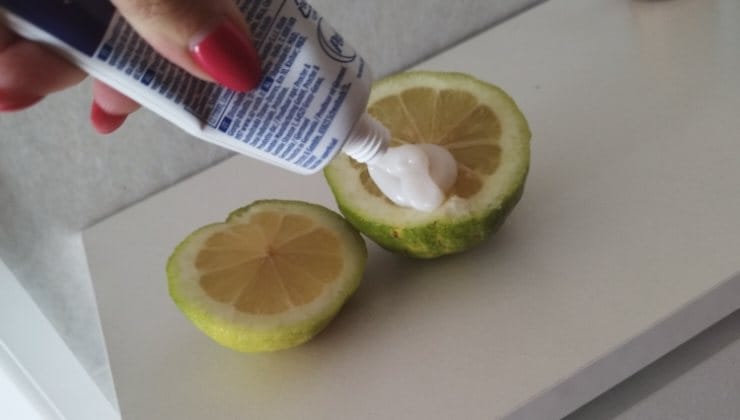 Dentifricio su limone per pulire la lavatrice