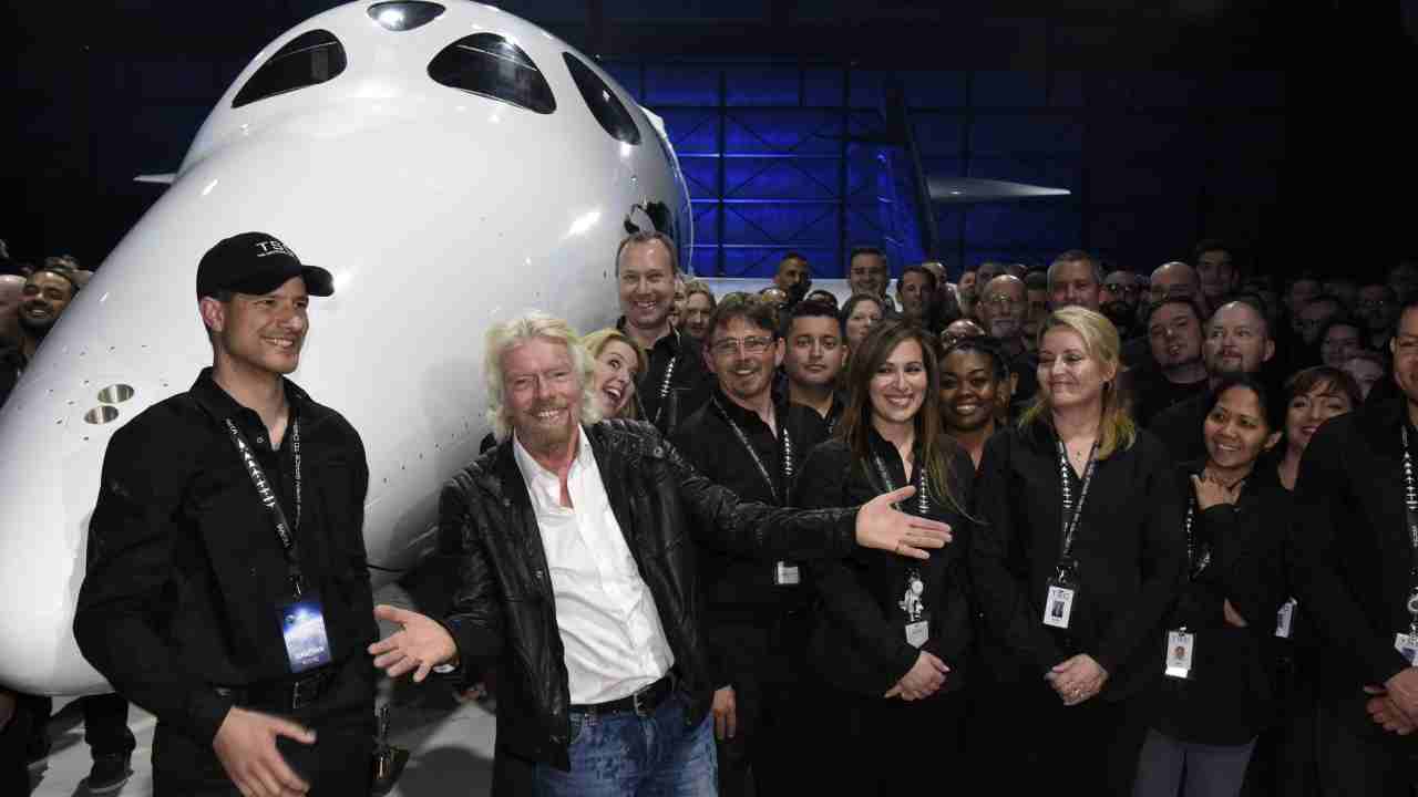 Richard Branson con una delle sue navicelle e i dipendenti di Virgin Galactic