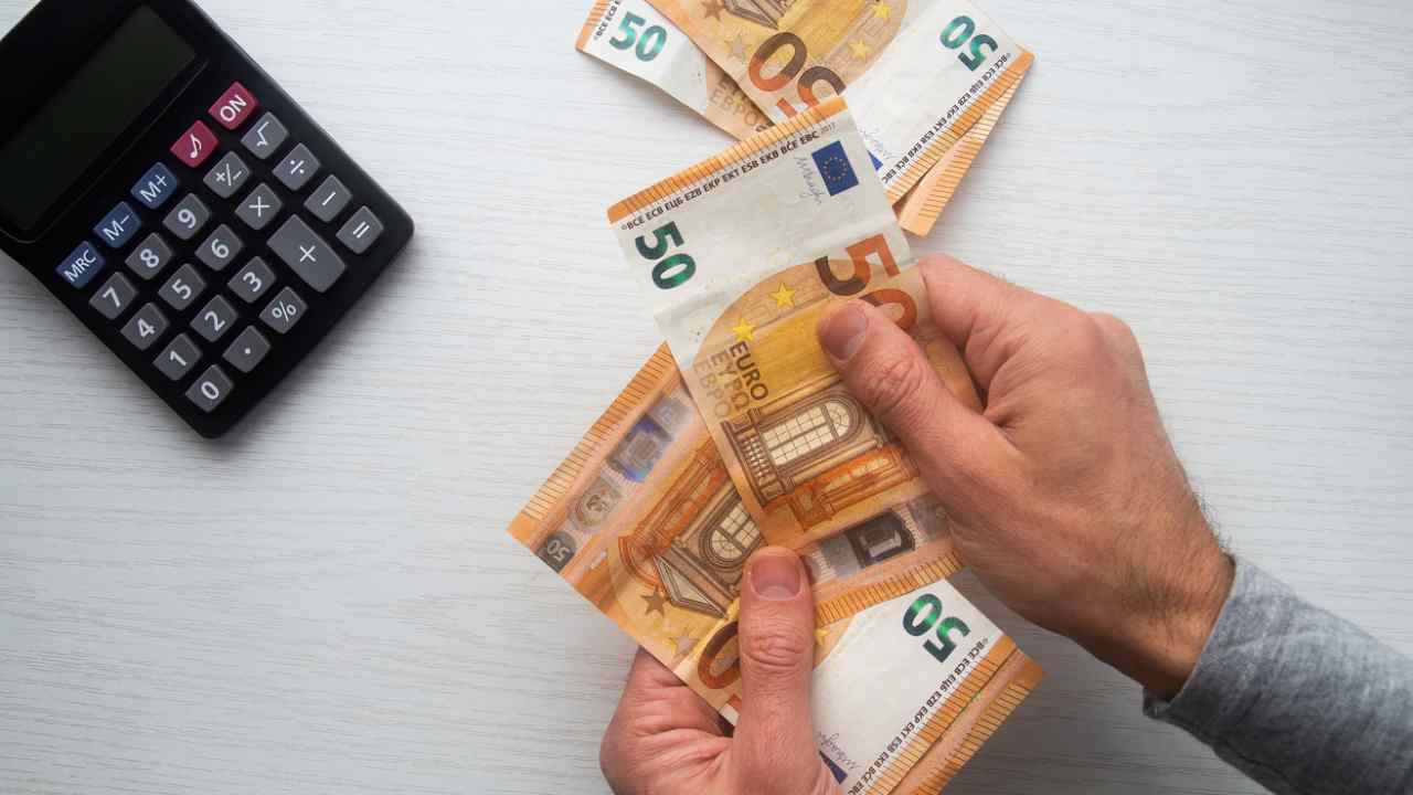 Calcolatrice e soldi in mano