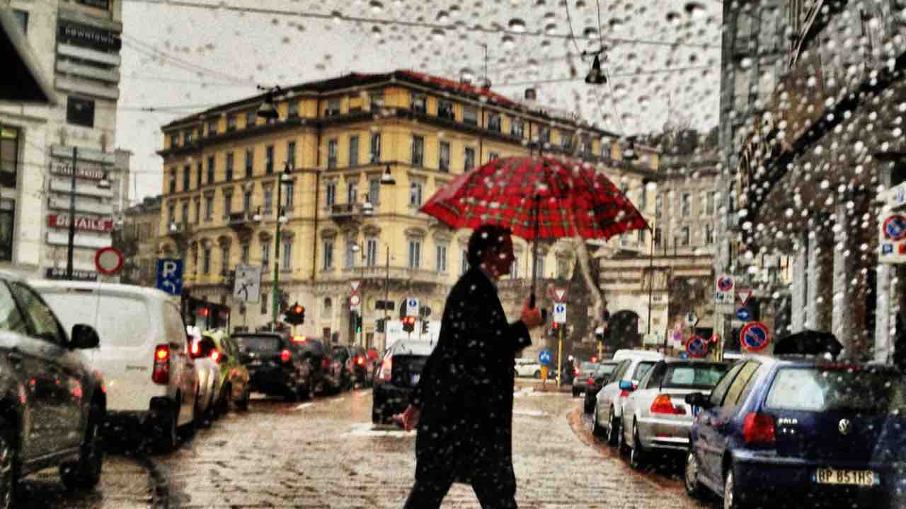 Milano, uomo con ombrello sotto la pioggia
