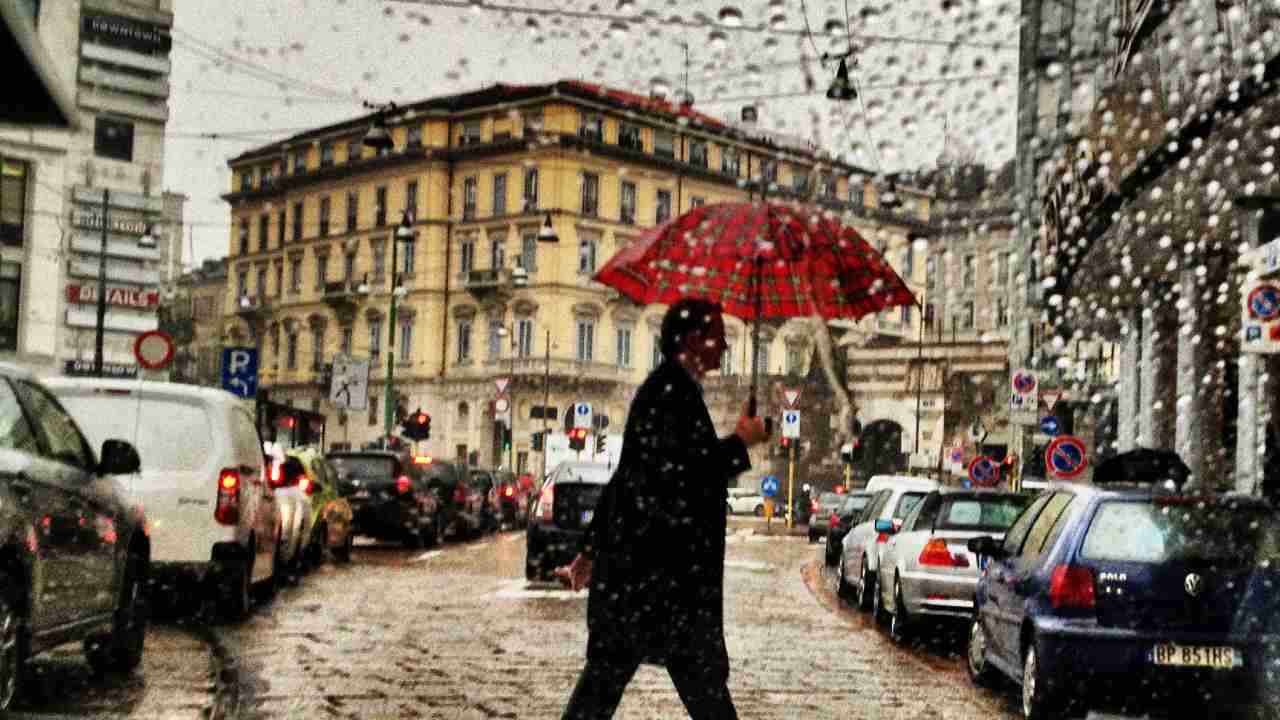 Un uomo sotto la pioggia a Milano
